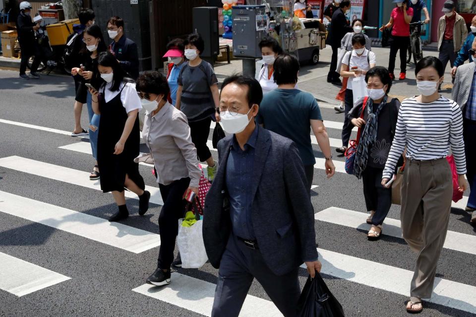 Pedestrians in face masks cross a street, amid the spread of the coronavirus disease in South Korea: REUTERS