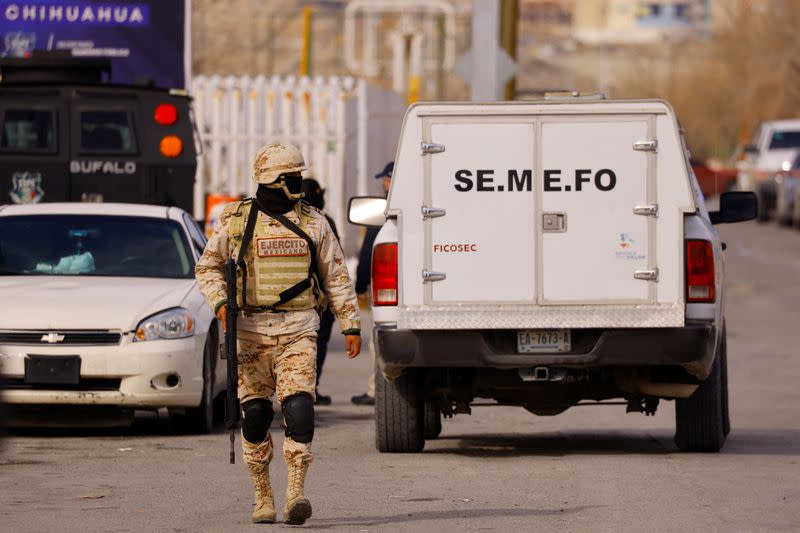 A member of the Mexican Army walks near a vehicle of the forensic medical service (SEMEFO) the Cereso state prison number 3 after unknown assailants entered the prison and freed several inmates, resulting in injuries and deaths, in Ciudad Juarez