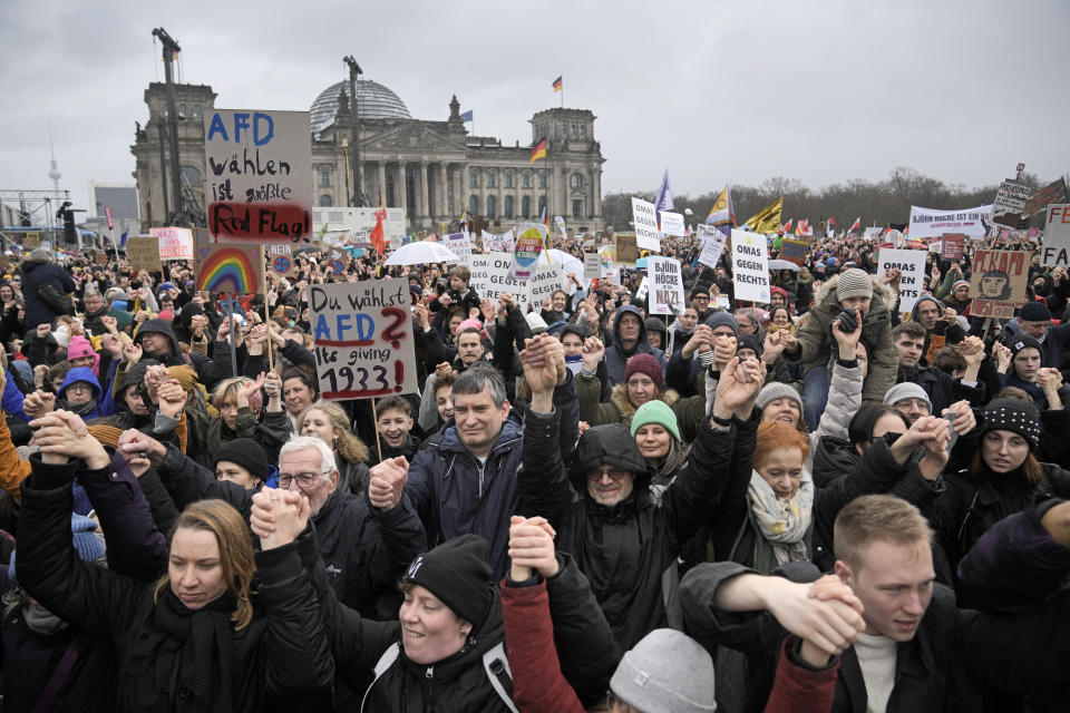 FILE - People hold hands in front of Germany's parliament at a demonstration against the far-right Alternative for Germany, or AfD, party and right-wing extremism in Berlin, Germany, Saturday, Feb. 3, 2024. Millions of Germans have joined rallies all over the country for weeks in a row, attending events with slogans such as "Never Again is Now." The protesters have been alarmed by the AfD's policies and its growing popularity. (AP Photo/Ebrahim Noroozi, File)