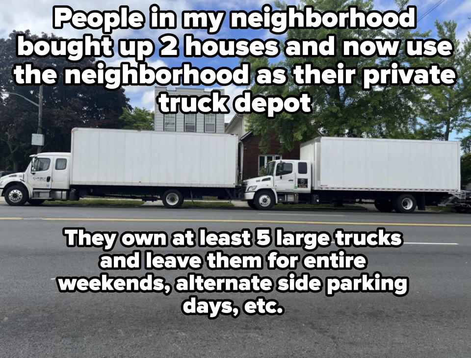 Two large white delivery trucks parked on a street in front of residential houses with trees lining the sidewalk