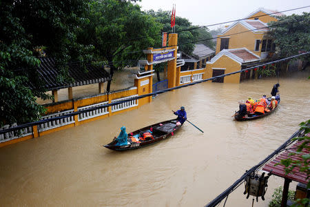 People ride a boat along submerged houses in UNESCO heritage ancient town of Hoi An after typhoon Damrey hits Vietnam November 6, 2017. REUTERS/Kham