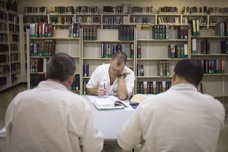 Offenders read and write papers inside the Southwestern Baptist Theological Seminary library located in the Darrington Unit of the Texas Department of Criminal Justice men's prison in Rosharon, Texas August 12, 2014. REUTERS/Adrees Latif