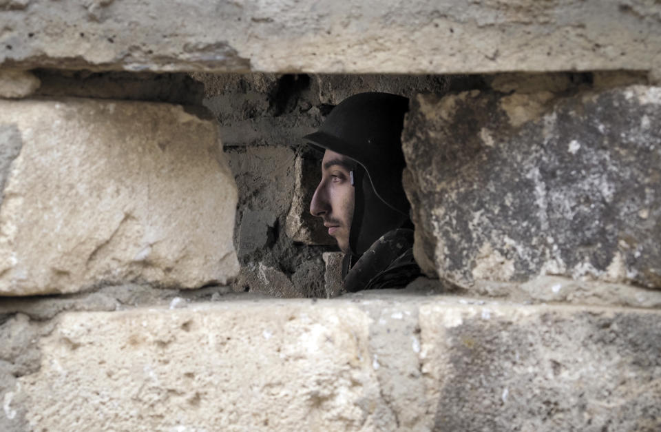 An Ethnic Armenian soldier is seen inside a dugout at a fighting position on the front line, during a military conflict against Azerbaijan's armed forces in the separatist region of Nagorno-Karabakh, Wednesday, Oct. 21, 2020. Armenia's prime minister has urged citizens to sign up as military volunteers to help defend the country amid the conflict with Azerbaijan over the disputed territory of Nagorno-Karabakh as intense fighting has raged for a fourth week with no sign of abating. (AP Photo)