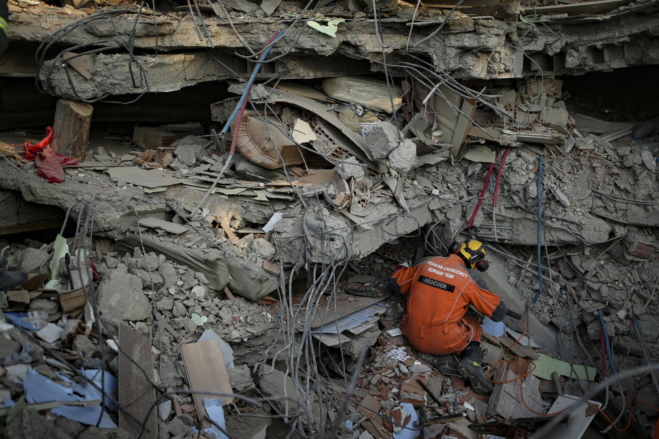 A Turkish rescue worker checks a collapsed building in Adiyaman, southern Turkey, Saturday, Feb. 11, 2023. Rescuers in Turkey miraculously continued to pull earthquake survivors out of the rubble on Saturday. The unlikely rescues, coming over four days after Monday's 7.8-magnitude quake brought down thousands of buildings in Turkey and Syria, offered fleeting moments of joy amid a catastrophe that has killed nearly 24,000 people, injured at least 80,000 others and left millions homeless.(AP Photo/Emrah Gurel)