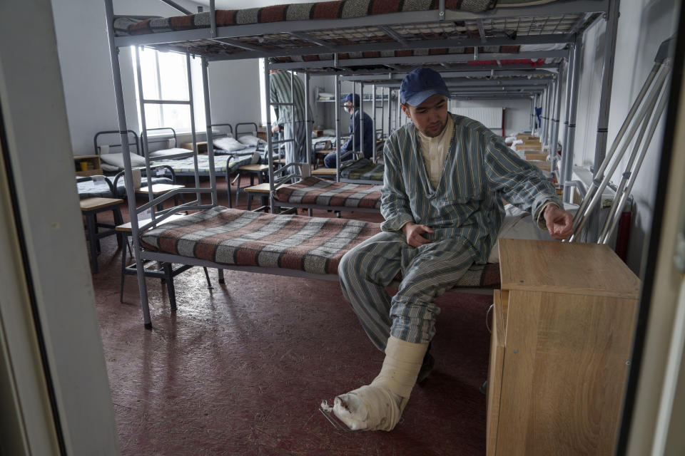 A captured Russian soldier sits on his bed at the prisoner of war detention center in Ukraine's Lviv region, Thursday, April 25, 2024. AP visited the center as part of a small group of journalists on the condition that its exact location be withheld. (AP Photo/Evgeniy Maloletka)