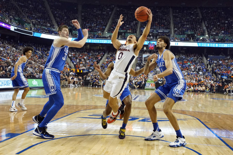 Virginia guard Kihei Clark (0) drives between Duke centers Kyle Filipowski (30) and Dereck Lively II (1) during the first half of an NCAA college basketball game for the championship of the Atlantic Coast Conference tournament in Greensboro, N.C., Saturday, March 11, 2023. (AP Photo/Chuck Burton)