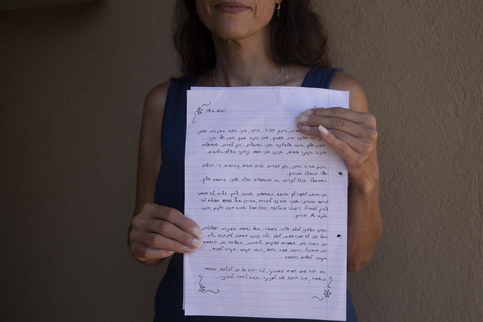 Idit Harel Segal, who donated a kidney to a Palestinian child from the Gaza Strip, holds with the letter she wrote to the boy, handwritten in Hebrew before giving him an Arabic translation, in her home in Eshhar, northern Israel, Tuesday, July 13, 2021. (AP Photo/Maya Alleruzzo)