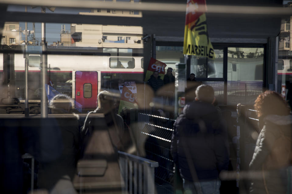 Railway workers are pictured in the reflection of a train window as they gather for a union general assembly meeting at the Gare St-Charles station in Marseille, southern France, Monday, Dec. 9, 2019. Paris commuters inched to work Monday through exceptional traffic jams, as strikes to preserve retirement rights halted trains and subways for a fifth straight day. (AP Photo/Daniel Cole)