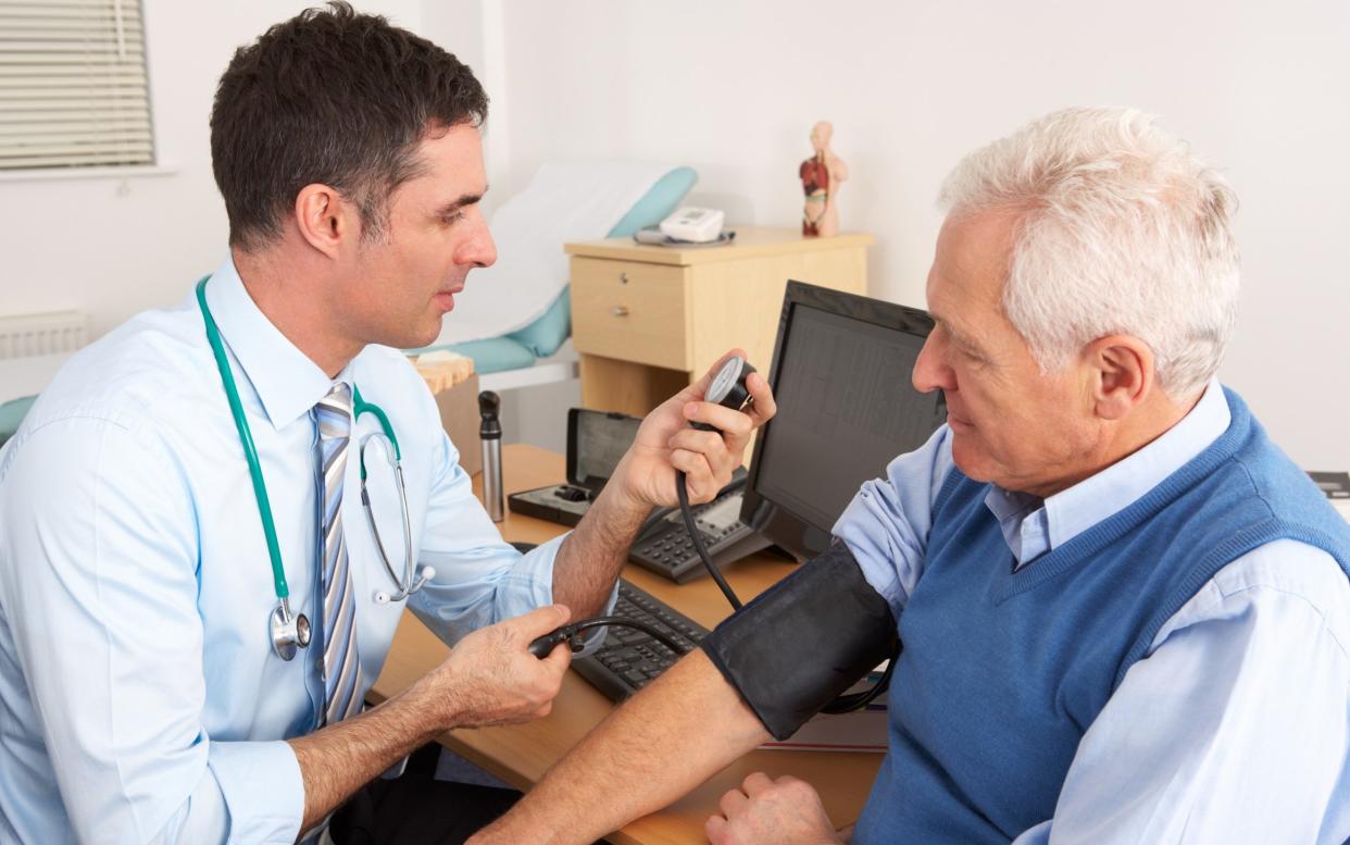 A British doctor seen taking a patient's blood pressure