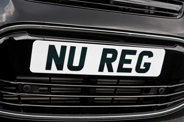 Registration plate on the front of a generic motorcar with "Nu Reg" in black letters on white background for New car sales