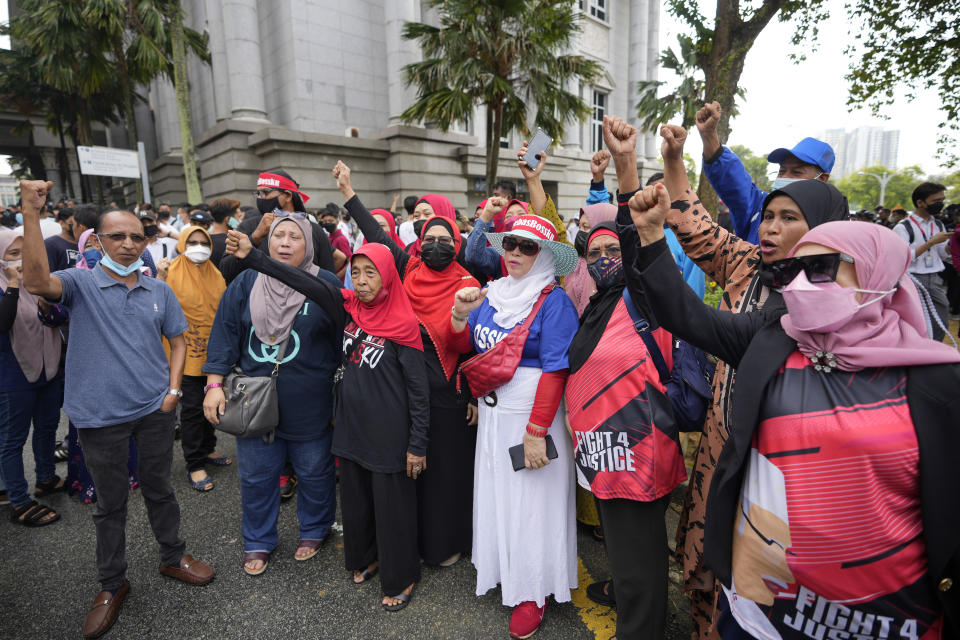 Supporters of former Malaysian Prime Minister Najib Razak, wearing a face mask shout slogan to show support while waiting outside at Court of Appeal in Putrajaya, Malaysia, Tuesday, Aug. 23, 2022. Najib was sentenced to 12 years in jail by a high court in July 2020, after being found guilty of abuse of power, criminal breach of trust and money laundering for illegally receiving 42 million ringgit ($9.4 million) from SRC International, a former unit of 1MDB. (AP Photo/Vincent Thian)