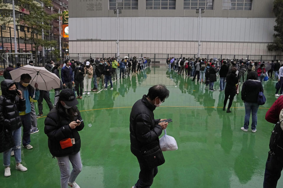 Residents line up to get tested for the coronavirus at a temporary testing center in Hong Kong, Thursday, Feb. 17, 2022. Hong Kong on Thursday reported 6,116 new coronavirus infections, as the city’s hospitals reached 90% capacity and quarantine facilities are at their limit, authorities said. (AP Photo/Kin Cheung)