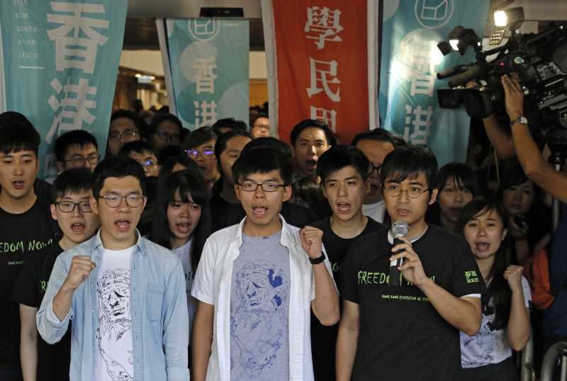香港「雙學三子」黃之鋒（中）、羅冠聰（左）及周永康（右）3年前發起衝擊「公民廣場」，開啟雨傘運動。2017年8月17日，3人遭判刑入獄，黃之鋒半年、羅冠聰8個月、周永康7個月。（AP）