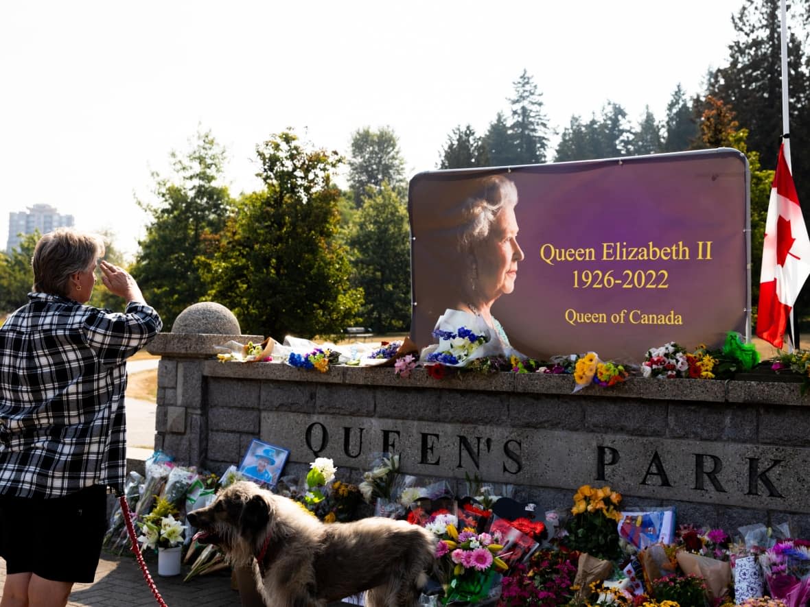 People pay their respects to Queen Elizabeth II at a memorial in Queen’s Park in New Westminster, B.C. (Justine Boulin/CBC - image credit)