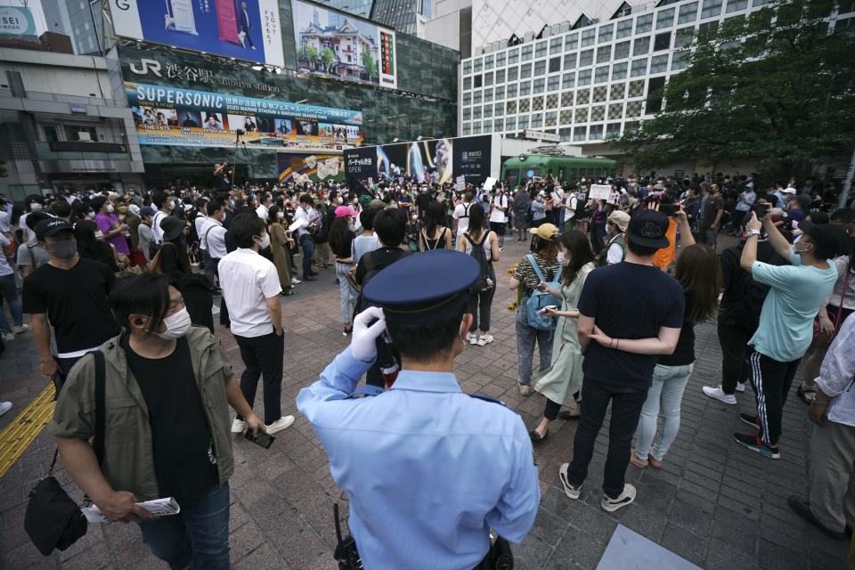 A police officer stands near people gathering to protest during a solidarity rally for the death of George Floyd Saturday, June 6, 2020, in Tokyo. Floyd died after being restrained by Minneapolis police officers on May 25. (AP Photo/Eugene Hoshiko)