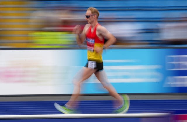 Race walker Callum Wilkinson in competition, centre, against a blurred background 