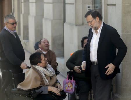 Spain's acting Prime Minister Mariano Rajoy talks to some people in wheelchairs on arrival at the Popular Party's provincial congress in Pontevedra in northwest Spain March 13, 2016. REUTERS/Miguel Vidal