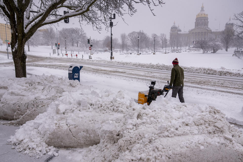 The Iowa State Capitol Building is visible as Spud Glaser of Carlisle, Iowa, plows the sidewalk in downtown Des Moines, Iowa, Tuesday, Jan. 9, 2024, as a winter snow storm hits the state. (AP Photo/Andrew Harnik)