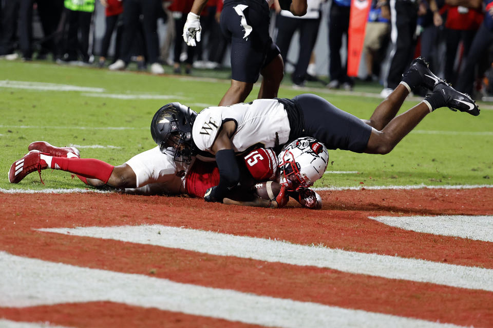 North Carolina State's Keyon Lesane (15) is tackled in the end zone after scoring by Wake Forest's DaShawn Jones, top, during the first half of an NCAA college football game in Raleigh, N.C., Saturday, Nov. 5, 2022. (AP Photo/Karl B DeBlaker)