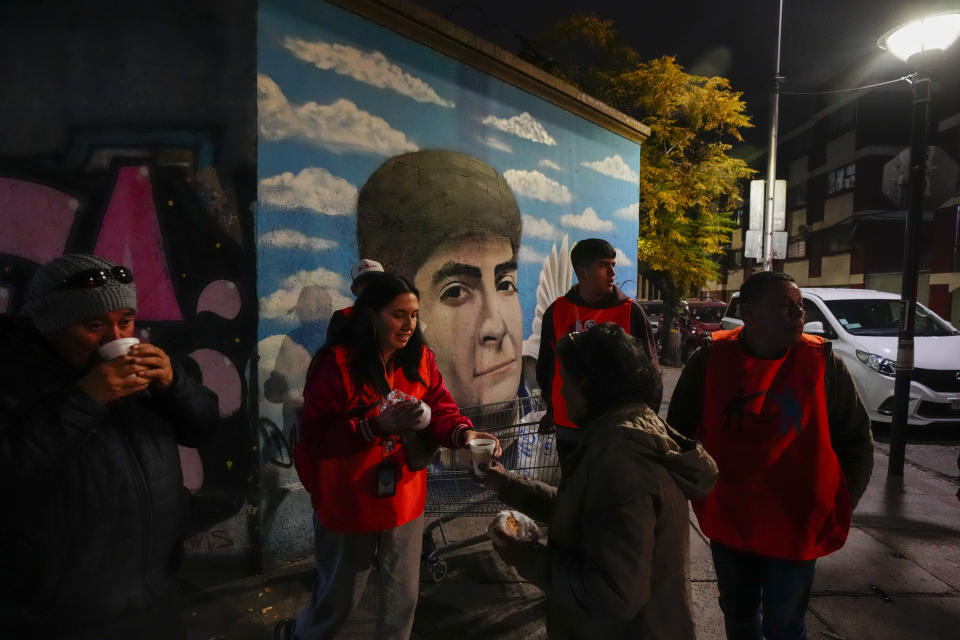 Voluntarios del albergue de Nuestra Casa reparten sandwiches y té a personas sin hogar en el barrio de Yungay en Santiago, Chile, el 6 de junio de 2024. En los últimos cuatro años, la tasa de indigencia en una de las economías más ricas de Sudamérica saltó más de un 30%. (AP Foto/Esteban Félix)