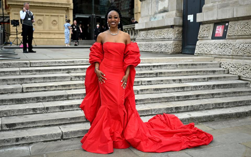 Beverley Knight stands alone in a strapless scarlet dress with a train