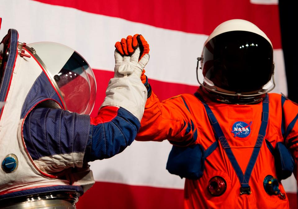 <p>Advance space suit engineer, Kristine Davis (L), gives a high five to lead engineer of the Orion Crew survival systems, Dustin Gohmert (R) during a press conference displaying the next generation of space suits as parts of the Artemis program in Washington, DC on October 15, 2019</p> (Photo by ANDREW CABALLERO-REYNOLDS/AFP via Getty Images)