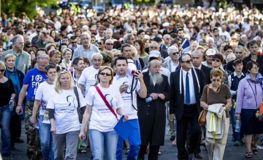 People march through the streets of the former Warsaw Ghetto during ceremonies marking the 70th anniversary of the start of Nazi Germany's mass deportation of Jews from the Warsaw Ghetto to the death camp of Treblinka