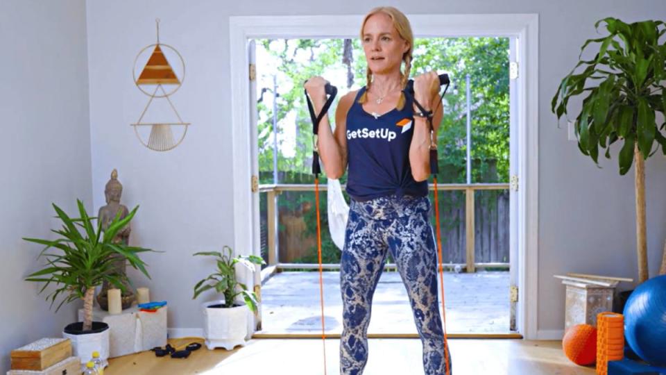 Woman demonstrating an arm workout with a resistance band