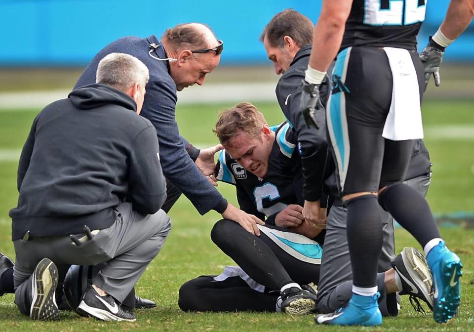 Carolina Panthers quarterback Taylor Heinicke holds his left arm as he is attended to by team physicians. Heinicke started one game for the Panthers in 2018, getting hurt in the second quarter.