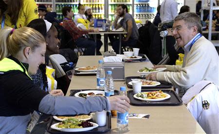 International Olympic Committee (IOC) President Thomas Bach (R) laughs as he eats lunch with athletes in the coastal Athlete's Village at the Sochi 2014 Winter Olympics February 1, 2014. REUTERS/Pascal Le Segretain/Pool