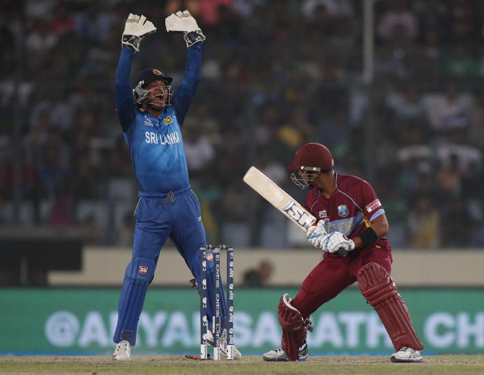 Sri Lanka's wicketkeeper Kumar Sangakkara, left, appeals successfully for the wicket of West Indies' batsman Lendl Simmons, right, during their ICC Twenty20 Cricket World Cup semi-final match in Dhaka, Bangladesh, Thursday, April 3, 2014. (AP Photo/Aijaz Rahi)