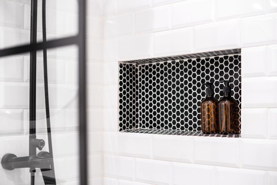 White tile shower with built-in black and white shower niche