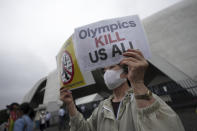 One of people against Olympic Games protests near Komazawa Olympic Park, where the unveiling ceremony for Olympic Flame of the Tokyo 2020 Olympic torch relay is held Friday, July 9, 2021, in Tokyo. (AP Photo/Eugene Hoshiko)