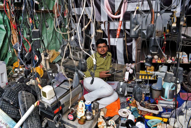 Seller looks on as he listens to a radio at a stall in a makeshift market in South Bishnupur