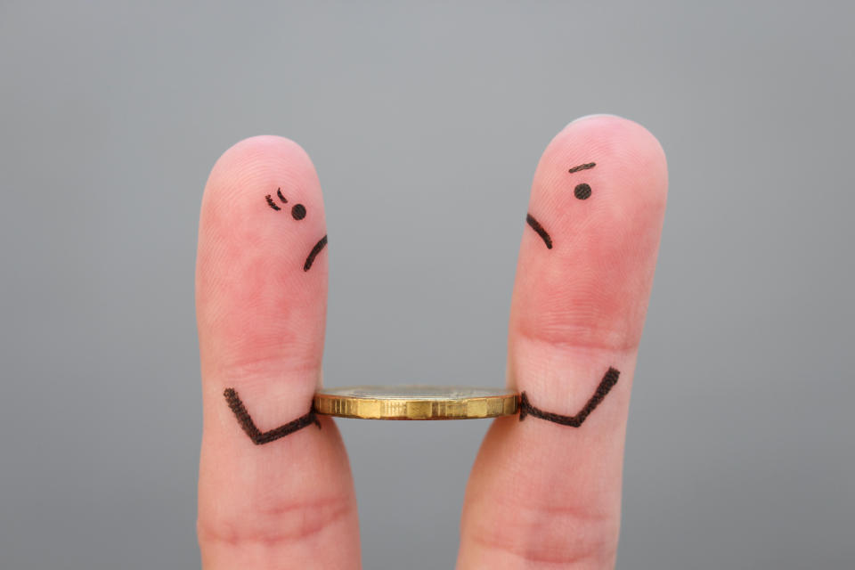 Two fingers with a dollar coin between them. 