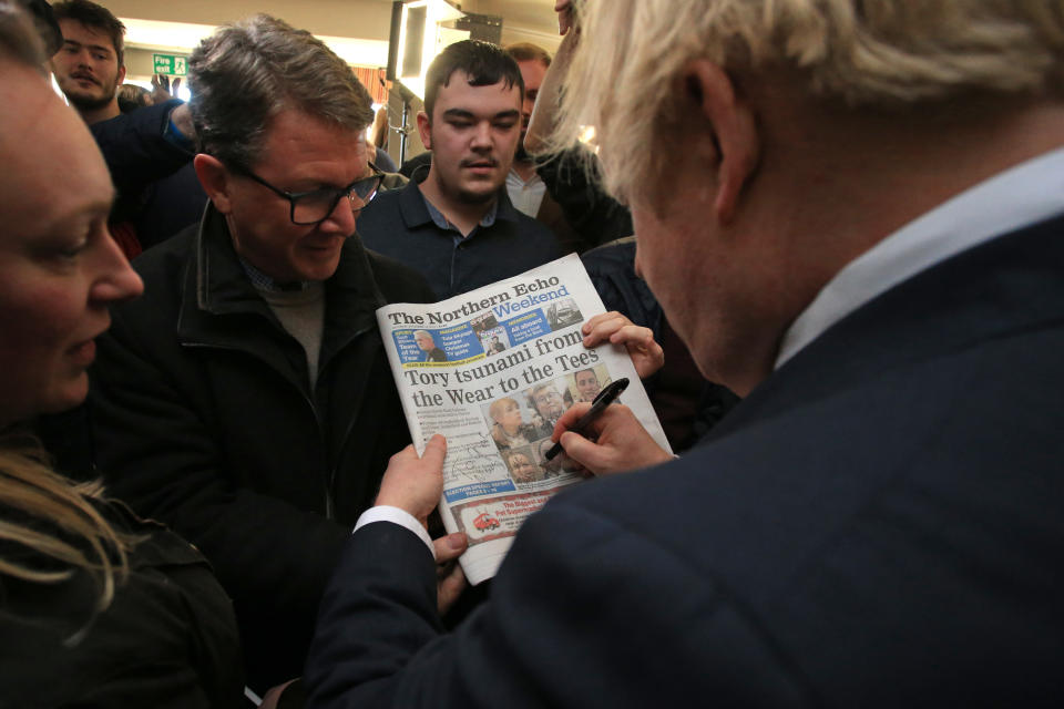 Prime Minister Boris Johnson signs a copy of The Northern Echo for a supporter during a visit to see newly elected Conservative party MP for Sedgefield, Paul Howell during a visit to Sedgefield Cricket Club in County Durham.