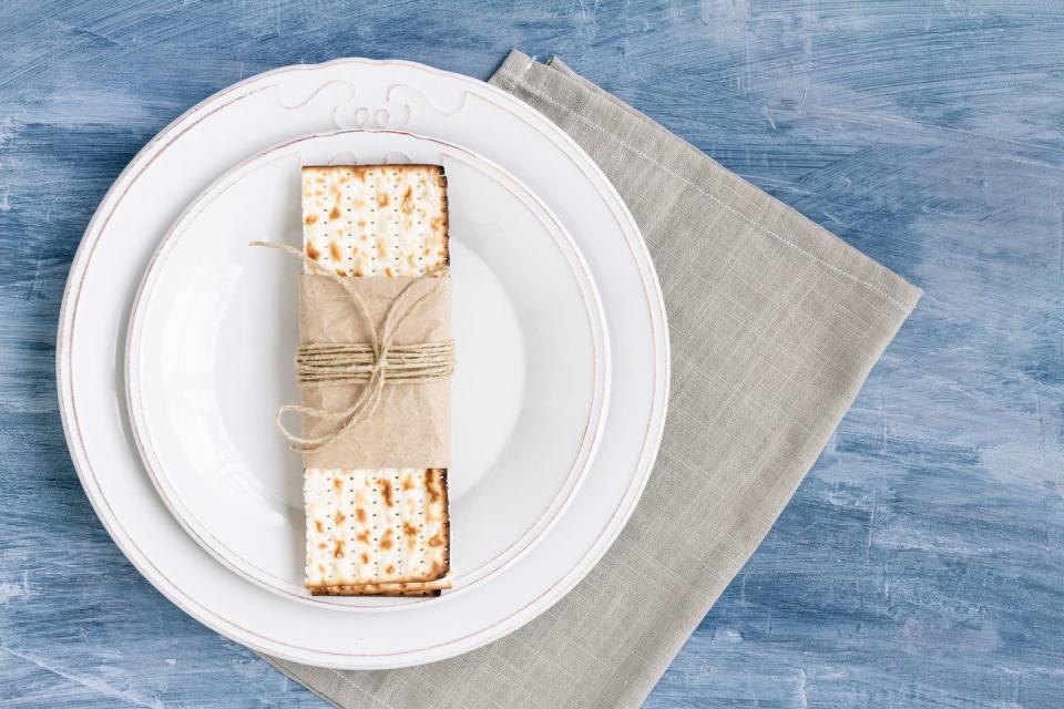 white plate with matzah or matza on a vintage table background presented as a passover seder feast or meal