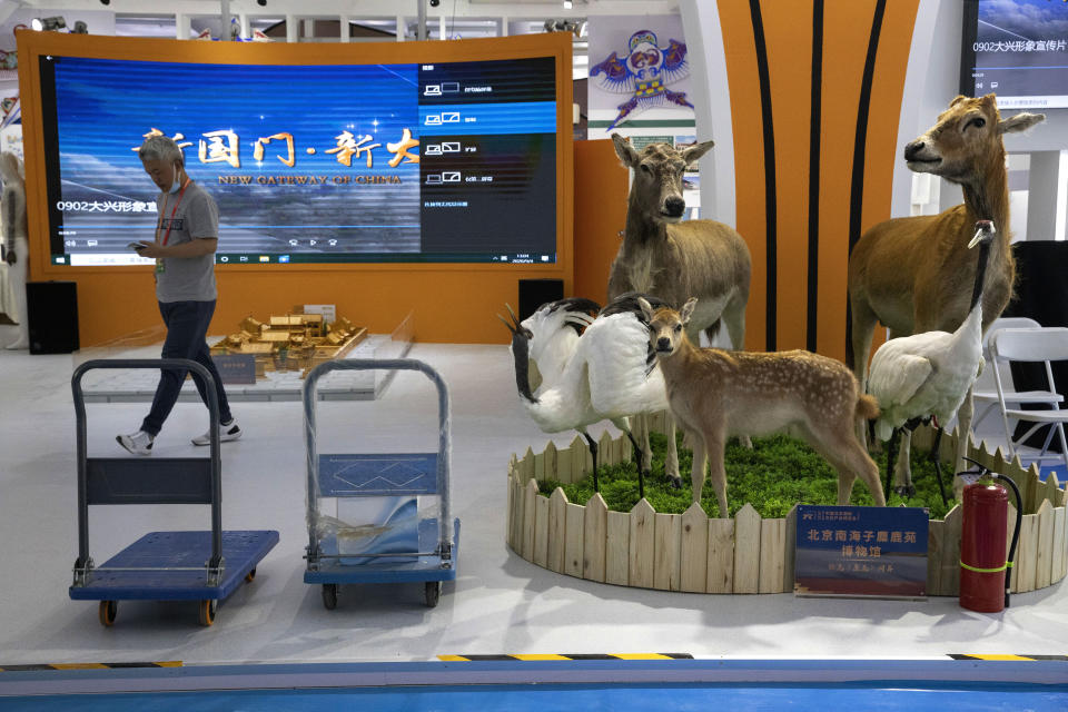 A worker walks by stuffed deers displayed at a regional booth specializing in cultural services at the China International Fair for Trade in Services (CIFTIS) to be held in Beijing on Friday, Sept. 4, 2020. As China recovers from the COVID-19 pandemic, business as usual is picking back up with the holding of the China International Fair for Trade in Services. Nearly 2,000 Chinese and foreign enterprises will participate and showcase their newest technology in public health and digital technology (AP Photo/Ng Han Guan)
