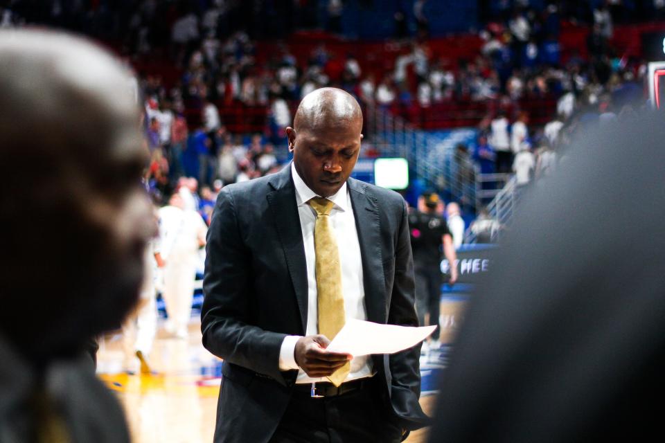Missouri head coach Dennis Gates reads a stat sheet during a college basketball game against Kansas at the Allen Fieldhouse on Dec. 9, 2023, in Lawrence, Kan.