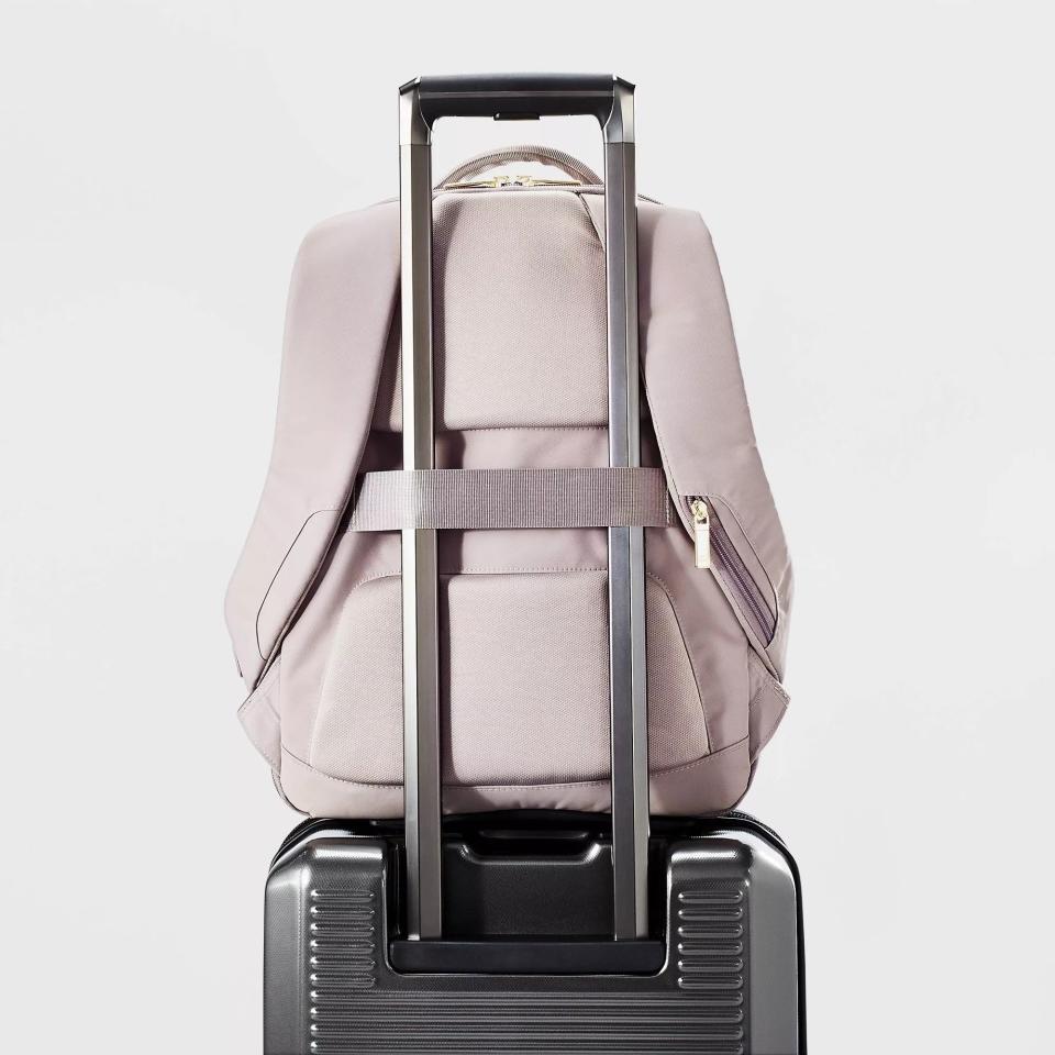 The bag attached to a suitcase via its trolley strap