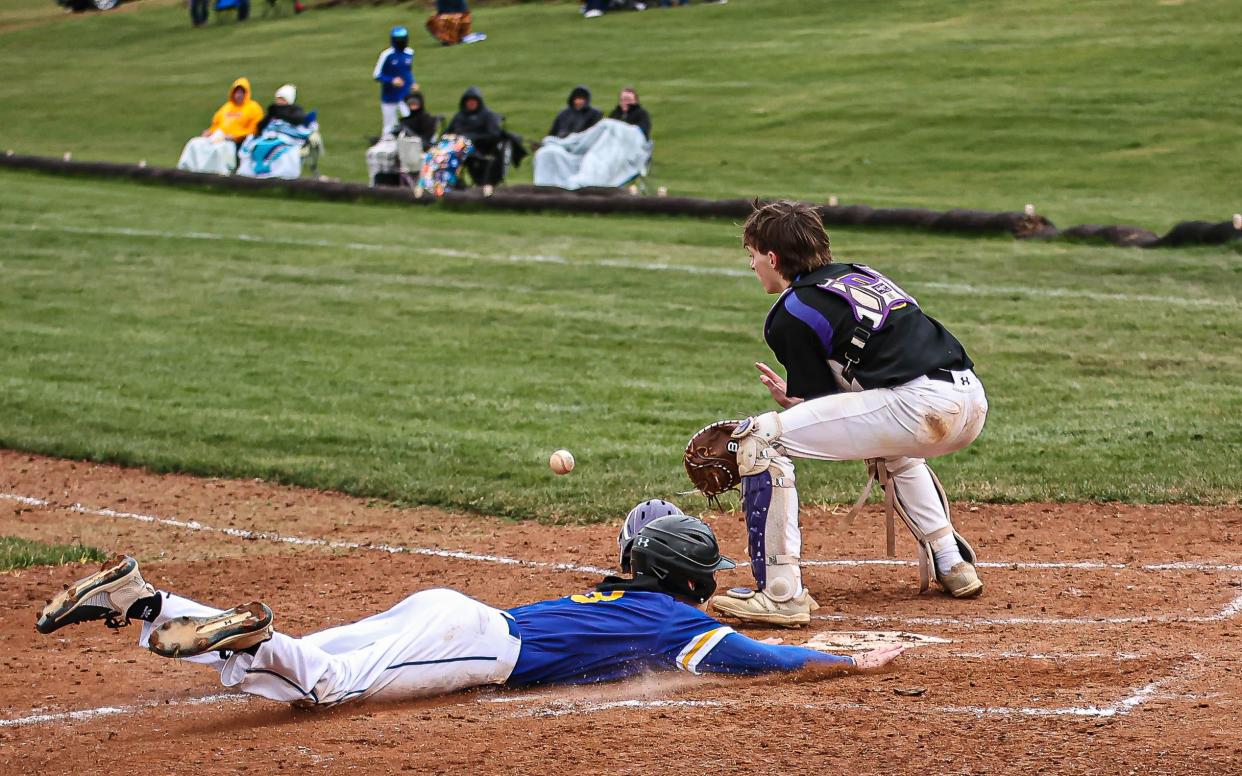 Levi Shoemaker (18) slides head first into home ahead of the throw to Andrew Richardson (8). The Northern Lebanon Vikings played host to the Lancaster Catholic Crusaders in a LL League Section 4 Baseball game on Friday April 5, 2024. The Vikings defeated the Crusaders 10-3.