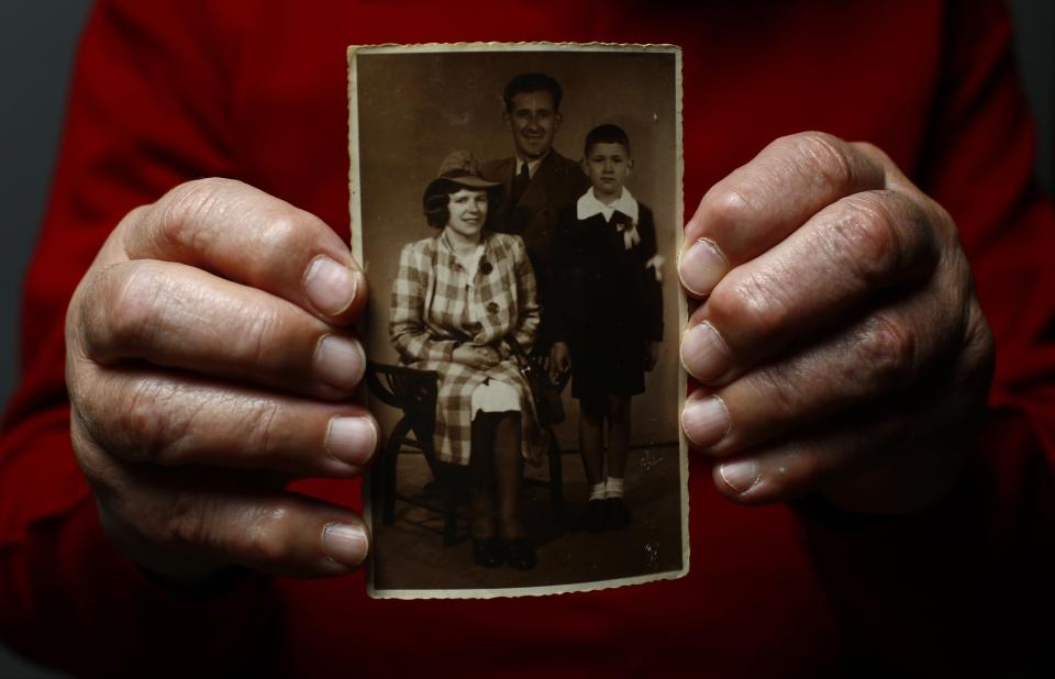 Auschwitz death camp survivor Bogdan Bartnikowski holds a family photograph as he poses for a portrait in Warsaw