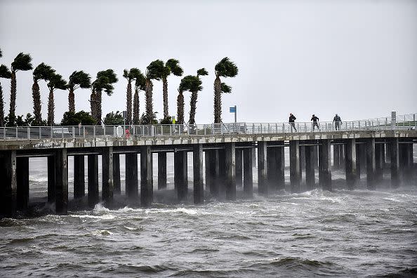 Local residents walk in the middle of rain and heavy wind at the St. Pete pier as the Hurricane Ian hits the west coast on September 28, 2022, in St. Petersburg, Florida.