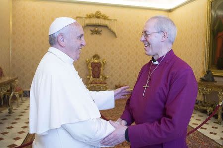 Pope Francis (L) shakes hands with the Archbishop of Canterbury Justin Welby during a private meeting at the Vatican June 16, 2014. REUTERS/Osservatore Romano