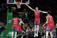 Boston Celtics guard Jaylen Brown (7) drives to the basket against Washington Wizards defenders Monte Morris (22), Corey Kispert, Kristaps Porzingis (6) and Deni Avdija (9) during the first half of an NBA basketball game Sunday, Nov. 27, 2022, in Boston. (AP Photo/Mary Schwalm)