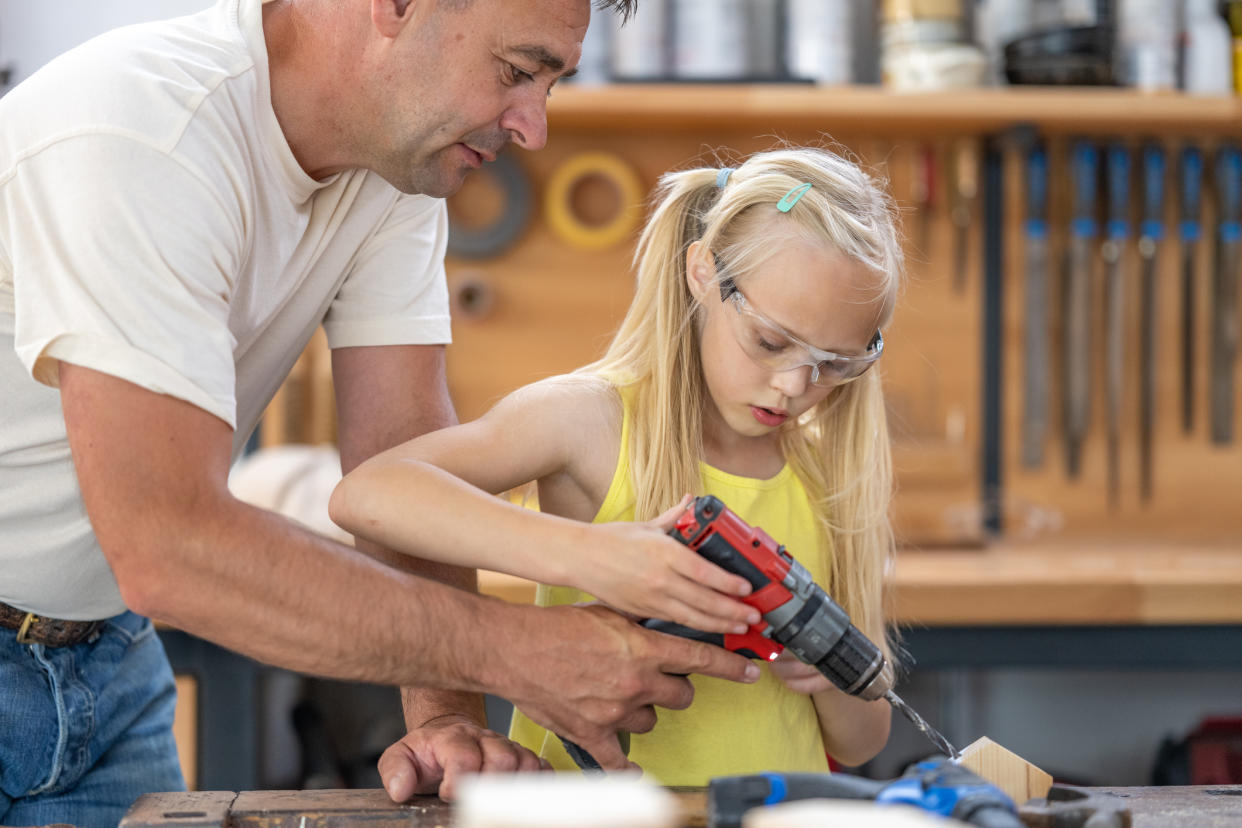  Girl making handmade house, screwing with electrical equipmen. 