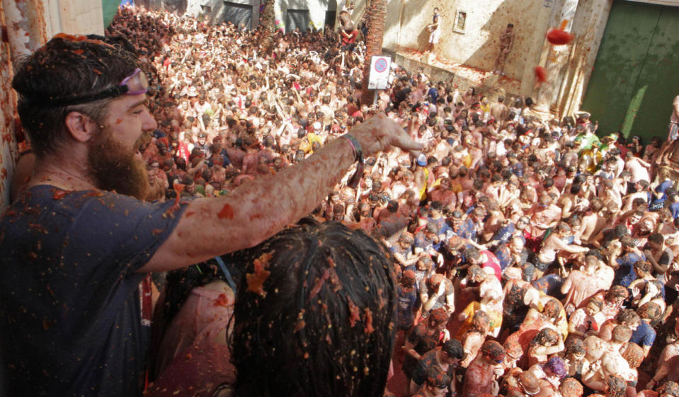 <p>Revelers throw tomatoes from a balcony during the annual “Tomatina”, tomato fight fiesta, in the village of Bunol, 50 kilometers outside Valencia, Spain, Aug. 31, 2016. (Photo: Alberto Saiz/AP)</p>