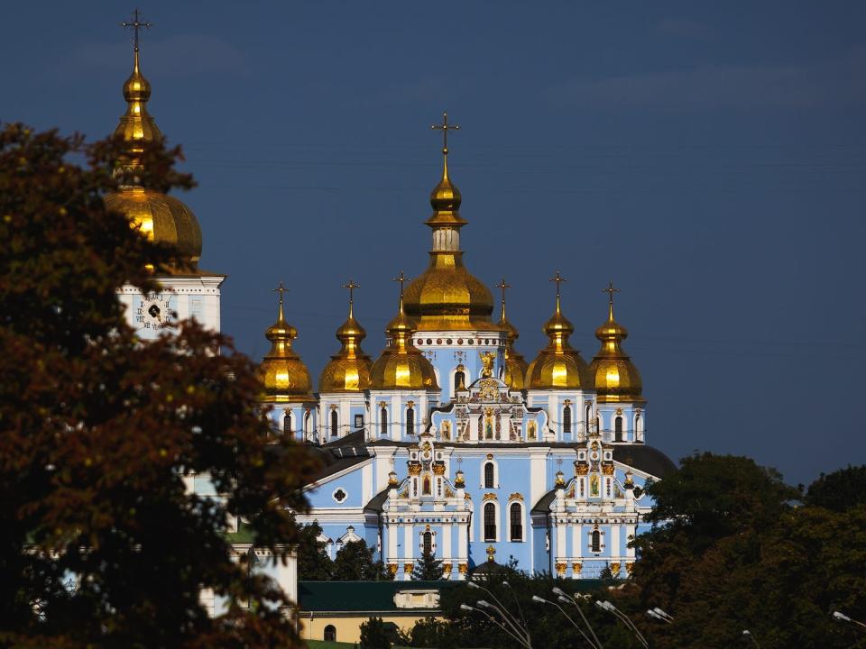St. Michael's Golden-Domed Monastery in Kyiv Ukraine: A gold-domed Orthodox church with pale multiple spires and pale blue walls.