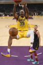 Los Angeles Lakers center Dwight Howard, left, dunks as Cleveland Cavaliers guard Dante Exum watches during the first half of an NBA basketball game Monday, Jan. 13, 2020, in Los Angeles. (AP Photo/Mark J. Terrill)