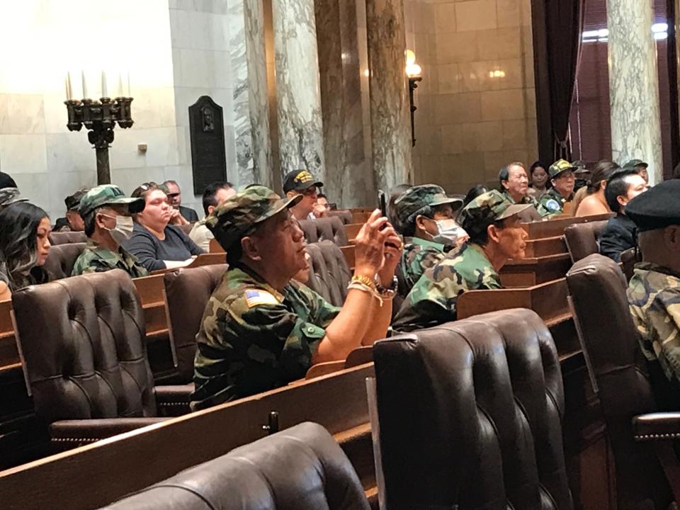 Hmong veterans take videos as the youngest son of Hmong leader Gen. Vang Pao speaks in the Assembly chambers of the state Capitol in Madison on Saturday, May 14, recognized as Hmong-Lao Veterans Day. The son, Chi Meng Vang, told them that they are all Americans who fight for the same country.